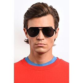 Man in rood shirt met donkere zonnebril op in aviator stijl.